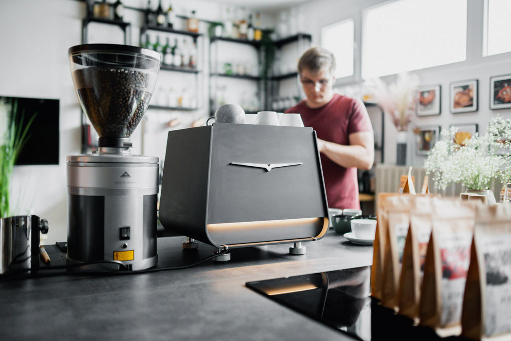 Kaffeemaschine Victoria Arduino Eagle One Prima, Kaffeemühle von Mahlkönig, Barista im Hintergrund