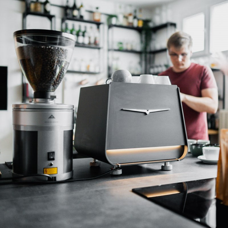 Kaffeemaschine Victoria Arduino Eagle One Prima, Kaffeemühle von Mahlkönig, Barista im Hintergrund